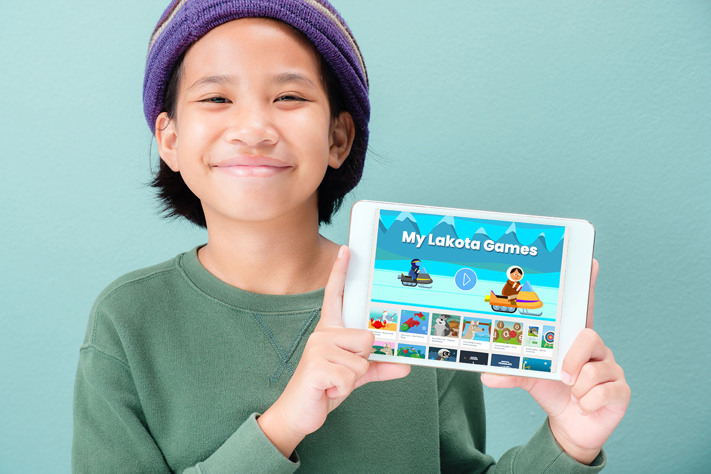 Indigenous child holding ipad that features games in their language.